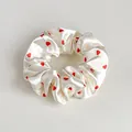 Dettaglio di un elastico per capelli in raso bianco perla con piccoli cuori rossi - Bianco Sporco