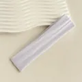 Nahaufnahme des hellvioletten elastischen Sportstirnbands mit weicher Strickstruktur und Design - Weiß