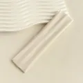 Detail eines cremefarbenen Sport-Stirnbands mit Rippenstrick-Struktur auf Gips-Untergrund - Beige