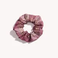 Vista dettagliata di un elastico scrunchie a quadri viola con motivo vintage e trama morbida - Tè nero al lampone