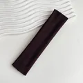 Dettaglio ravvicinato della trama della fascia elastica in maglia marrone scuro su bianco - Marrone scuro