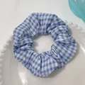 Blue and white checkered pattern scrunchie made of soft fabric on a white tray - Bright Blue Plaid