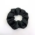 Close-up of black satin scrunchie showing smooth silk-like texture and detailed fabric folds - Black