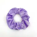 Detailansicht des lila Satin-Haargummis mit seidiger Textur und plissiertem Design - Lila