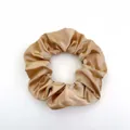 Detailed view of champagne gold satin scrunchie showing glossy texture and soft folds - Satin 9