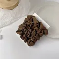Detail of a large brown satin scrunchie with silk-like sheen on a display card - Deep Coffee
