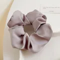Chouchou en satin violet lilas avec des plis doux sur un plateau de présentation blanc - Mauve Clair