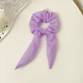 Detailansicht eines hellvioletten Organza-Haargummis mit langen Bändern auf weißem Grund - Lila