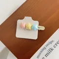 Dettaglio di fermagli per capelli a stella opachi in rosa, giallo e blu su cartoncino - Piccole Stelle Multicolore