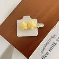Dettaglio di fermagli per capelli a stella gialla su espositore in legno con carta - Stella Grande Gialla