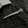 Polished silver metal hair sectioning clip with dot patterns on textured black background - Large / Silver