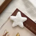 Nahaufnahme der weißen flauschigen Stern-Haarklammer mit weicher Textur und süßem Look - Weiß
