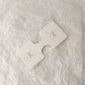 Close-up of white handmade jewelry display card with bow logo on textured paper - Dumbbell Shape (Hand made) / White