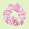 Pink satin scrunchie with smooth silk texture and natural pleats on a green background - Light Pink