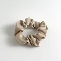 Elegant champagne satin scrunchie with a glossy silk-like finish and soft pleated texture - Khaki
