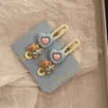 Detail von süßen Bären- und Herz-Haarspangen auf einer I Love You Forever Karte - Blauer Herz Bär Armband