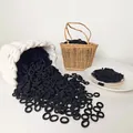 Close-up of bulk seamless black high-elastic hair ties in a woven basket display - Black
