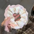 Détail d'un chouchou en dentelle rose avec motifs d'oursons et un petit nœud élégant - Chouchou Ours Rose