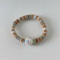 Chouchou en maille arc-en-ciel à rayures orange et blanches avec une grande perle nacrée - Palette De Couleurs Jaune Gingembre Et Gris