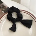 Coletero elegante de satén negro con lazo colocado sobre un plato cerámico - Negro