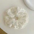 Detalle de coletero floral con ribete de encaje blanco y estampado de flores púrpuras - Floral Púrpura