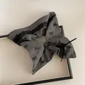 Détail du chouchou gris à pois avec dentelle noire et pendentif doré élégant - Style Foulard Carré Bordure Dentelle Nœud Gris