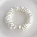 Détail macro du chouchou en satin blanc avec une grande perle brillante élégante - Blanc