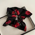 Dettaglio ravvicinato di un elastico per capelli nero con rose rosse in stile vintage - Elastico per Capelli a Sciarpa