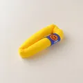 Detailed macro view of a lemon yellow knitted hair clip with a blue smiley face label - Yellow