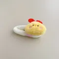 Detail of cute plush yellow chick hair scrunchie with red bow on soft white fabric - Chick Side Clip