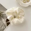 Eleganter Haargummi aus cremefarbenem Organza auf weißem Keramikteller präsentiert - Doppellagiges Mesh / Gebrochenes Weiß