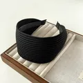 Macro detail of wide black knitted headband featuring pleated texture and elastic fabric - Black