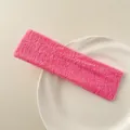 Detail of rose pink terry cloth sports headband on a white ceramic plate - Pink