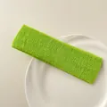 Detail of bright green terry cloth sports headband on a white ceramic plate - Green