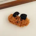 Primer plano de una linda pinza de pelo de peluche marrón con un lazo negro decorativo - Cachorro color café con lazo negro