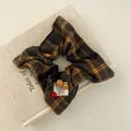 Gros plan sur un chouchou à carreaux rouges avec perles et étiquette sur un livre - Foulard Carré Carreaux Perles Café