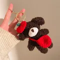 Detailansicht eines Plüschbär-Schlüsselanhängers mit roter Strickmütze und Tasche - Dunkelbrauner Bär mit rotem Rucksack