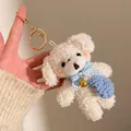 Detail von weißem Plüsch-Hundeanhänger mit blauer Schleife und kleiner Tasche - Weißer Bär mit blauem Rucksack