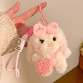 Close-up of plush rabbit keychain with pink bow, knit bag, and soft textured fabric - Pink Bag Bunny