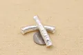 Makroaufnahme von gebogenen Silberperlen mit geprägten buddhistischen Mantra-Details - Silber