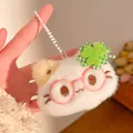 Close-up of white plush cat keychain with green clover and pink glasses held in hand - Glasses Style