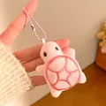Detailed view of pink plush turtle keychain with red embroidery and matching bead chain - Pink