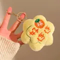 Nahaufnahme gelber Plüschblumen-Schlüsselanhänger mit Persimone-Stickerei und Goldclip - Gelb