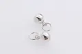 Close-up of polished silver ball pendants with closed rings for DIY jewelry making - 6mm