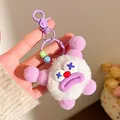 Close-up of fluffy white monster keychain with purple details and colorful letter beads - Purple Antenna White Ball