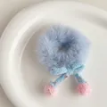 Detail of light blue plush scrunchie with a knitted bow and pink pom-pom accents - Blue