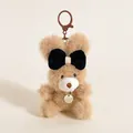 Détail d'un pendentif ours en peluche doux avec nœud noir et médaillon doré - Ours Café