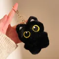 Gros plan du porte-clés chat en peluche noire avec yeux jaunes et fermoir doré chic - Petit Porte-clés Chat Noir / 9x8cm