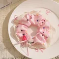 Gros plan d'un chouchou à carreaux roses avec bordure en dentelle et pois colorés. - Rose à Carreaux et Pois avec Cœur et Nœud