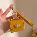 Nahaufnahme eines senfgelben Mini-Taschen-Schlüsselanhängers mit goldener Hardware - Orange